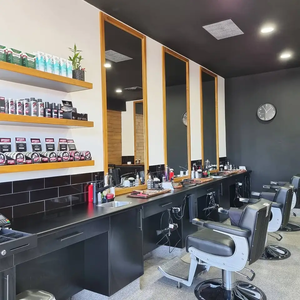 Inside the shop: black barber stations, mirrors and the timber wall