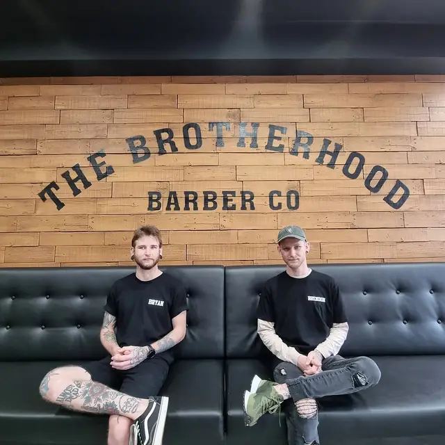 Bryan and Brendon on the lounge under the wall sign